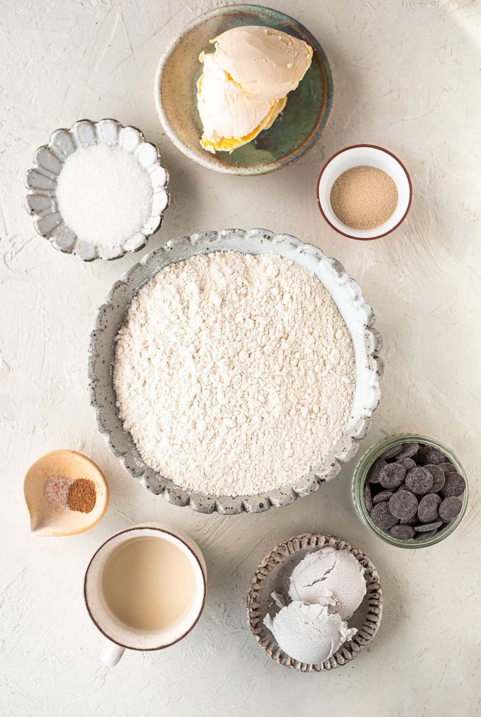 Ingredients for making vegan chocolate babka including flour, butter, sugar, yeast, cinnamon, salt, milk, chocolate and coconut cream